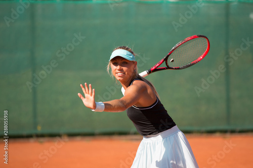 Tennis - woman hitting tennis ball photo