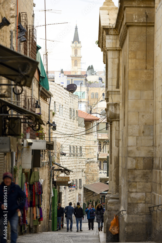 Locals and tourists walks through the streets of the Old City of Jerusalem. Jerusalem is a city in the Middle East, located on a plateau in the Judaean Mountains, Israel.