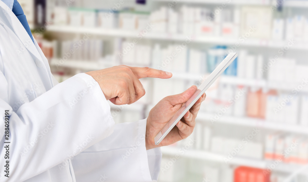 Pharmacist making notes on a digital tablet Pharmacist making notes on a digital tablet