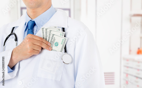 Doctor putting banknotes in pocket