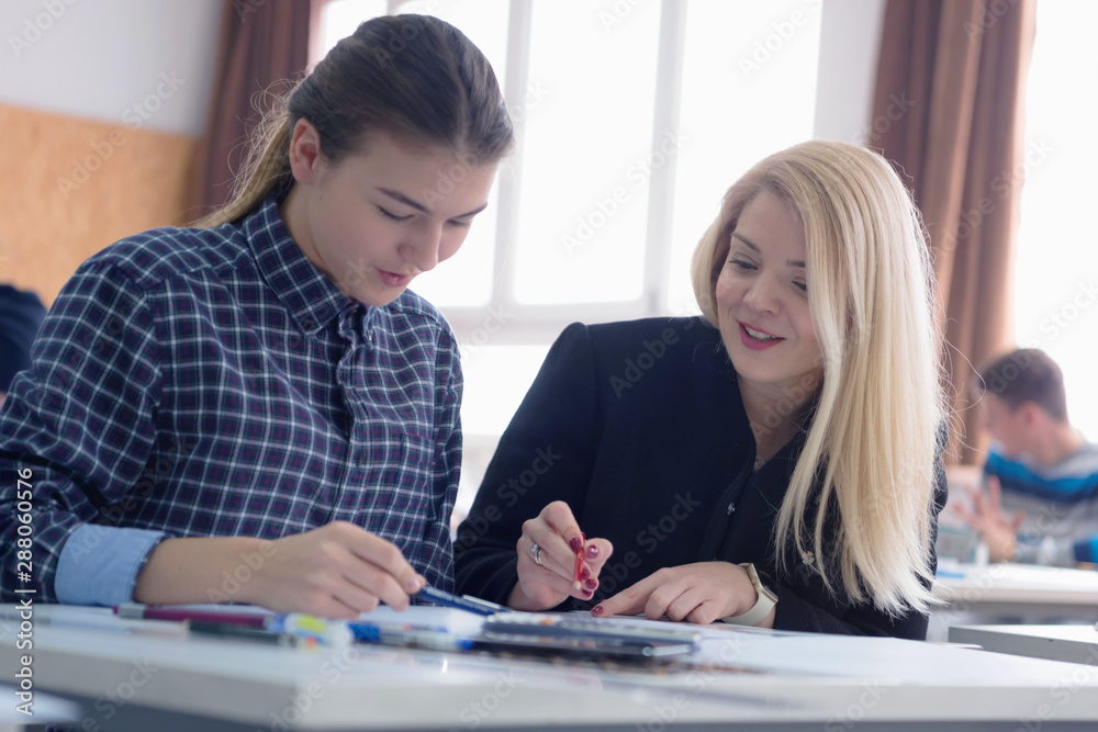 Fototapeta premium Female Architecture teacher at work. Female professor explain architectural projects to students. Beautiful female university architecture professor explain lessons to multiethnic students.