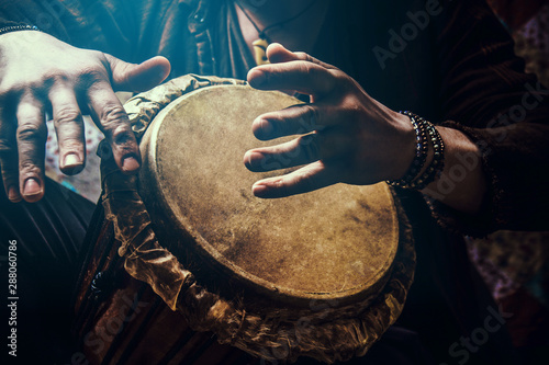 Foto A man playing an ethnic percussion musical instrument jembe