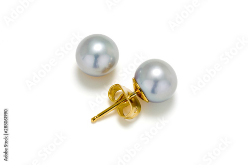 Grey pearl stud earrings in gold on a white background.