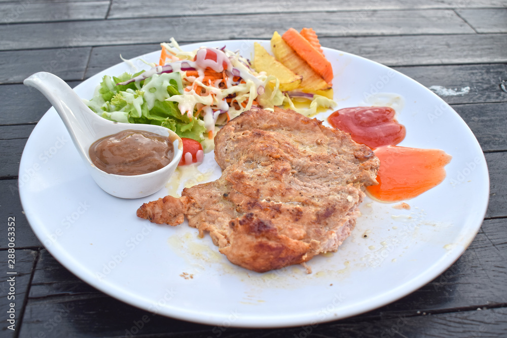  Pork steak with vegetable salads and sauces is a delicious and popular dish.