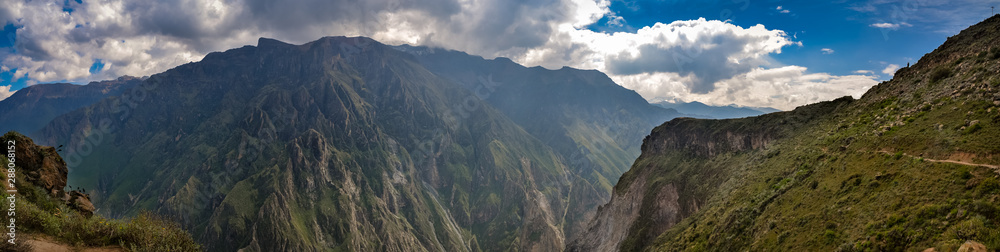 A panoramic view of the valley at Mirador Cruz del Cóndor in Peru on a partially cloudy day