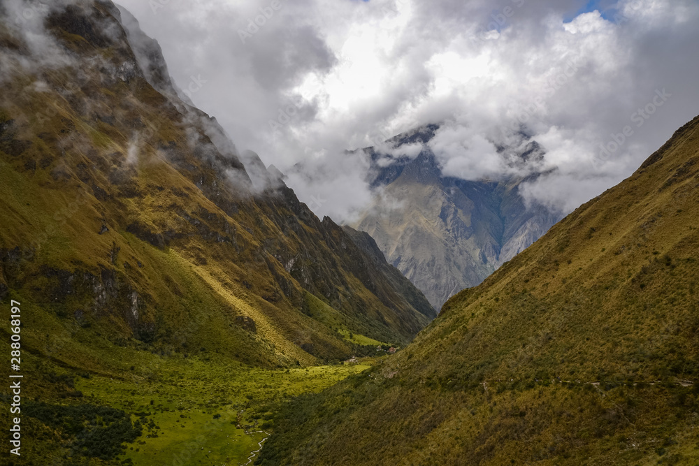 Dark green valleys dominates the landscapes around the Inca trail on this fog and overcast day in Peru