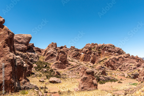 Brown and dry rock formation that look like small mountains on clear and Sunday in Portal de Aramu Muru, Peru.