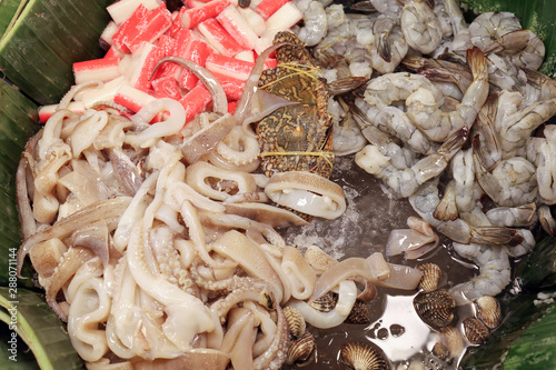 Ready to cook raw fish shrimp cuttlefish cockle crab in banana leaf  on cold ice photo