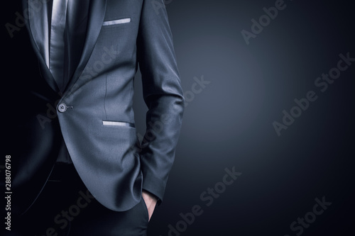 Obraz na plátně Business man in a suit on a gray background
