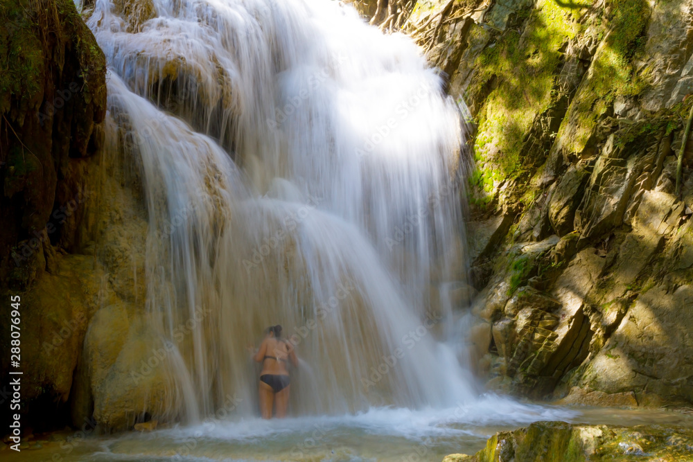 Obraz premium Woman with bikini black enjoy water at Erawan Waterfall