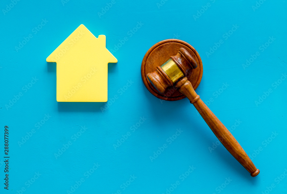 Inscribed gavel, house figure for inheritance concept on blue background top view
