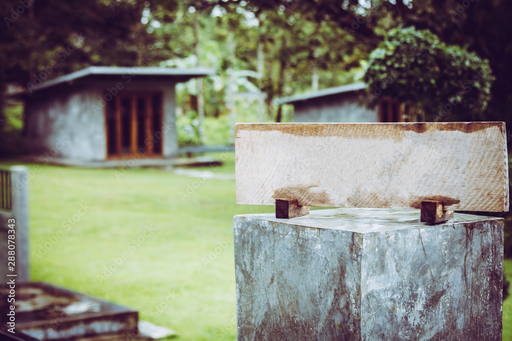 Fototapeta premium Empty sign made of wood on the cement pole on garden background.