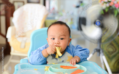Asian baby boy 6 months old eating with Baby Led Weaning (BLW) method, Self-Feeding