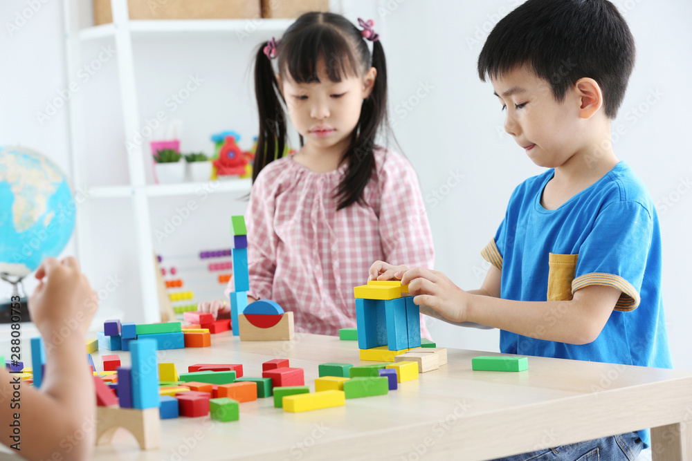 Asian preschool student build block toys at home or daycare. Cheerful kid playing with color cubes. Educational toys for preschool and kindergarten children. Asian preschool student build block toys at home or daycare. Cheerful kid playing with color cubes. Educational toys for preschool and kindergarten children.