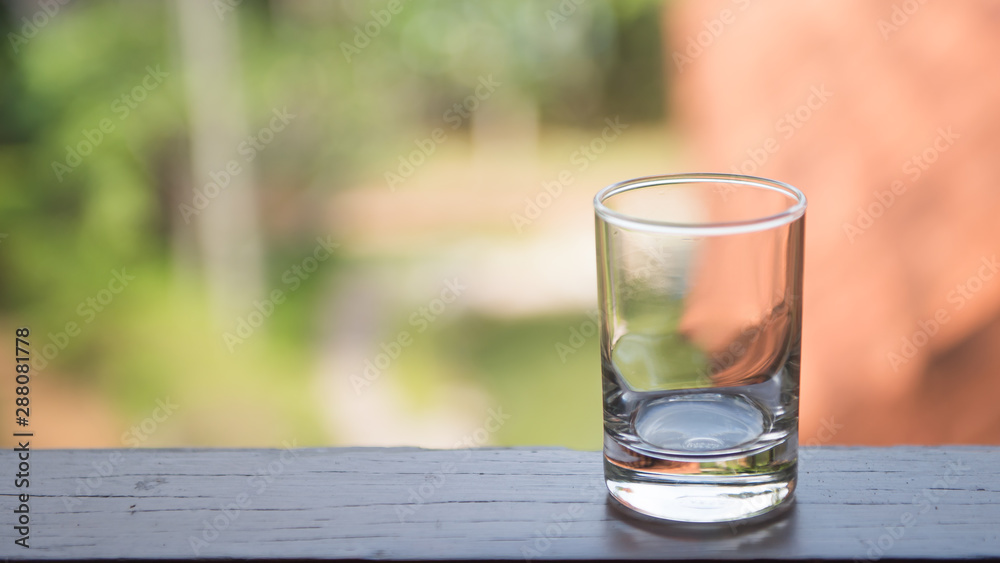 glass of water on green background of blue sky glass of water on green background of blue sky