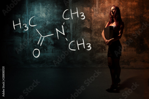 Sexy girl or secretary or female student presenting handdrawn chemical formula of Dimethylacetamide photo