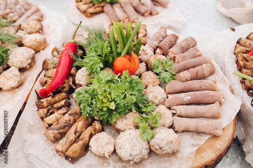 Huge plate serving appetizing meat snack and vegetable ready for eating top view. View from above fresh juicy cotlet pork roll organic tomato and greenery spicy red pepper photo