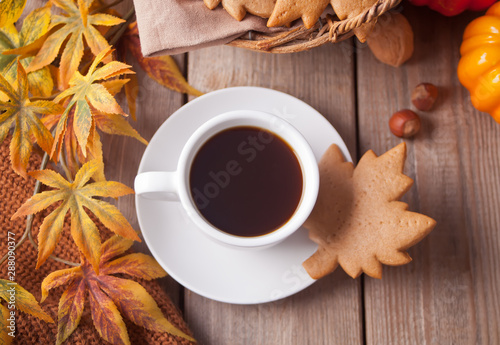 Cup of coffee, autumn leaves, pumpkin, cookies on the wooden table. Autumn harvest. Autumn concept. Top view.