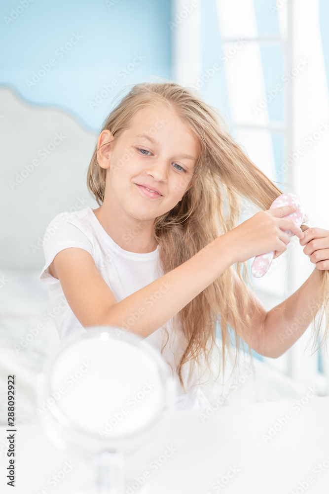 Young girl combing hair in the morning at home Young girl combing hair in the morning at home