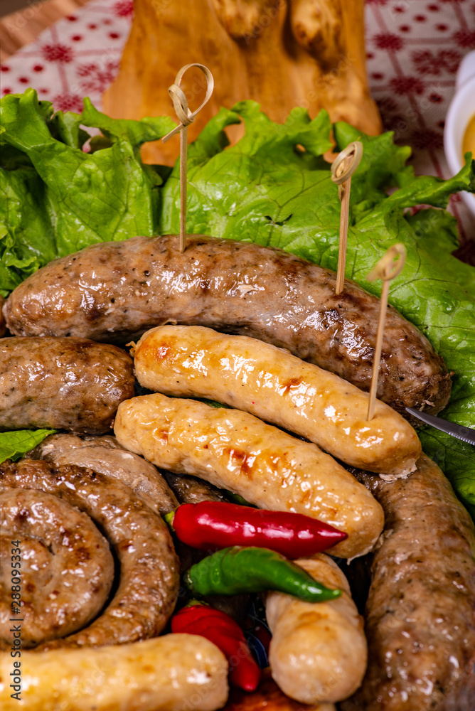 Background of grilled sausages with a leaf of lettuce and hot pepper. Background of grilled sausages with a leaf of lettuce and hot pepper.