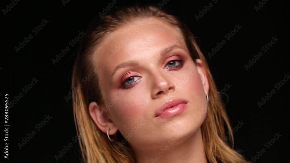 Close-up portrait of a girl on a black isolated background. Blonde with wet hair posing in the studio. Close-up portrait of a girl on a black isolated background. Blonde with wet hair posing in the studio.