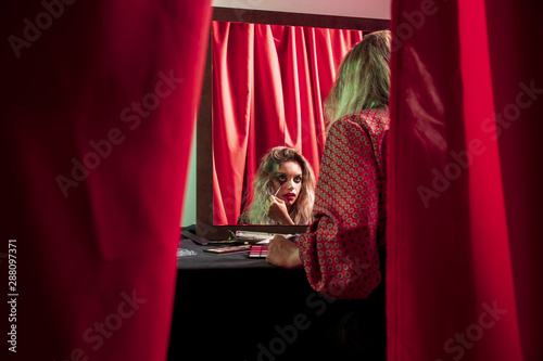 Shot between curtains of a dressed woman