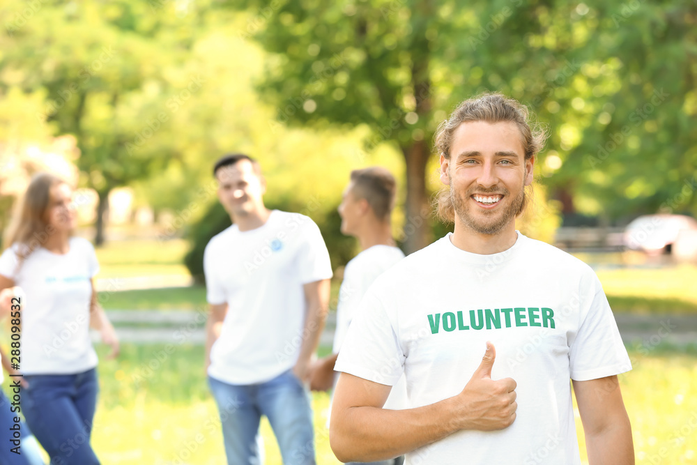 Portrait of male volunteer showing thumb-up outdoors Portrait of male volunteer showing thumb-up outdoors