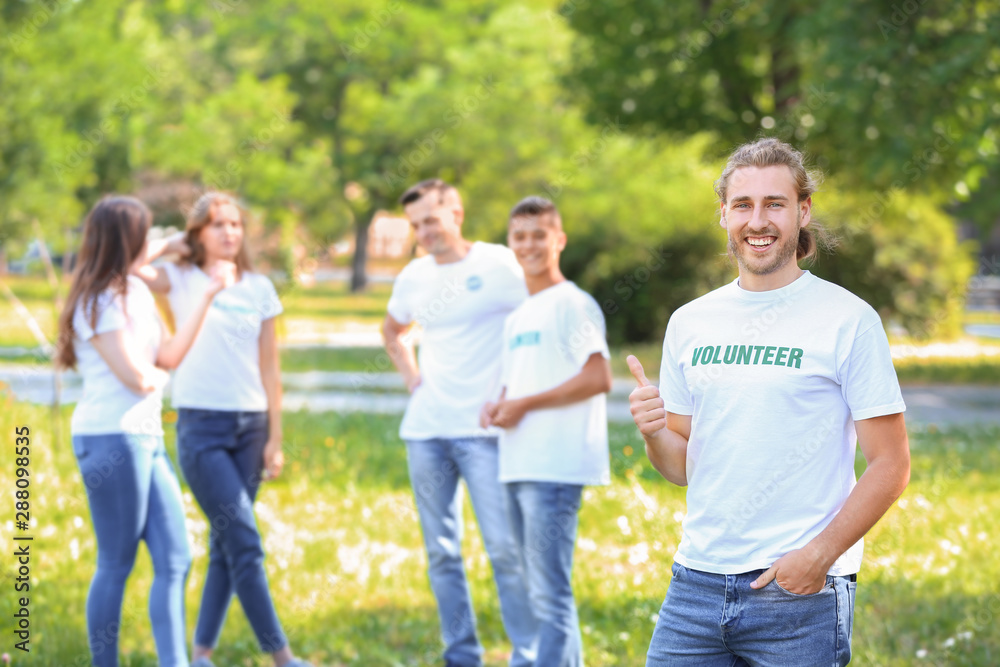Portrait of male volunteer with his team outdoors Portrait of male volunteer with his team outdoors