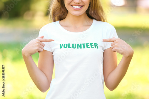 Female volunteer pointing at her t-shirt outdoors