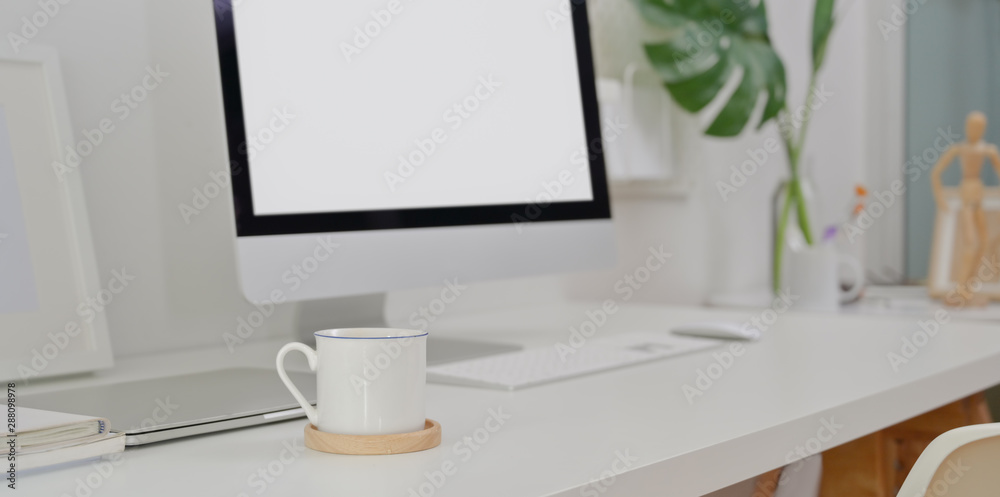 Modern workplace with desktop computer and blank screen laptop with copy space Modern workplace with desktop computer and blank screen laptop with copy space