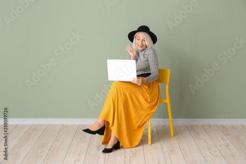 Mature woman with laptop si...