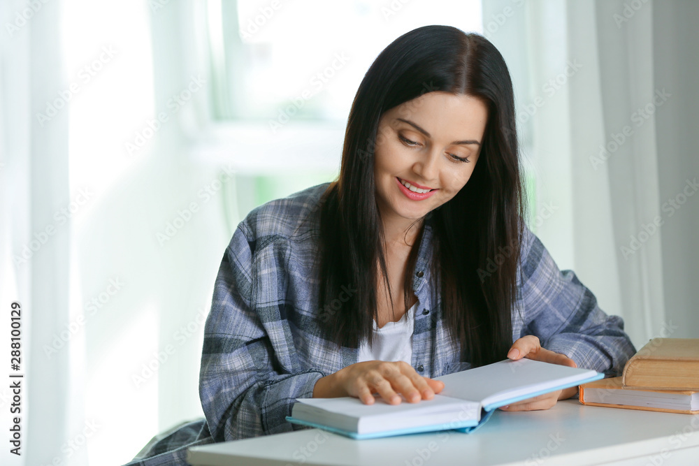 Beautiful young woman reading book at home Beautiful young woman reading book at home