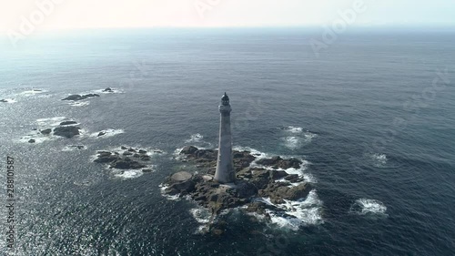 Aerial slow motion high above Skerryvore lighthouse in shimmering sunshine