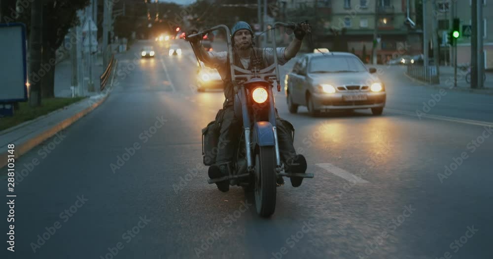 Man riding custom motorcycle in evening city Man riding custom motorcycle in evening city