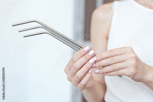 Girl is holding stainless steel straws to reduce the amount of plastic waste in the environmen