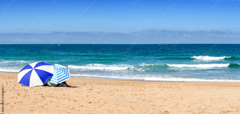two umbrellas on beach background, blue sky