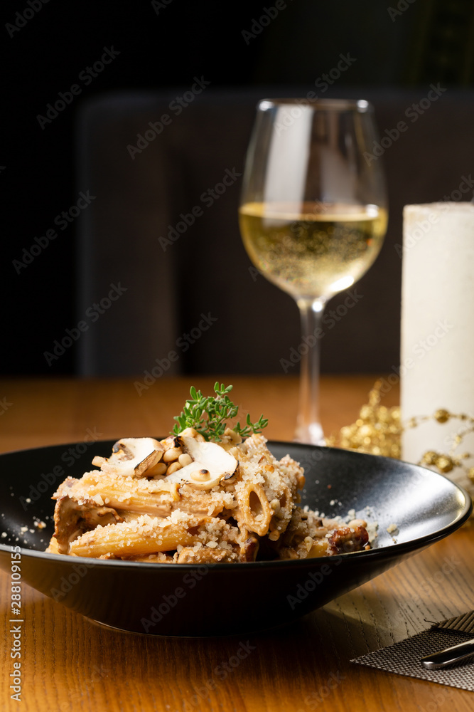 Penne pasta with mushrooms sauce close-up and wine