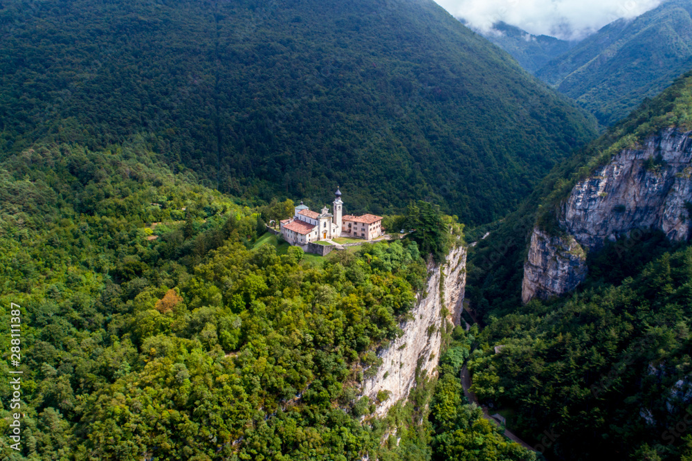 Sanctuary on the edge of the cliff in the Alps - aerial view