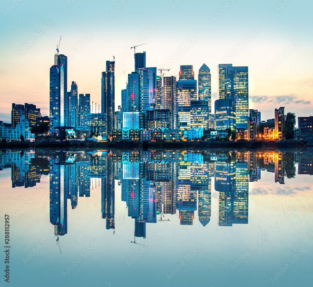 Fototapeta premium Canary Wharf business and banking area at sunset with beautiful reflection in the River Thames water. London, UK