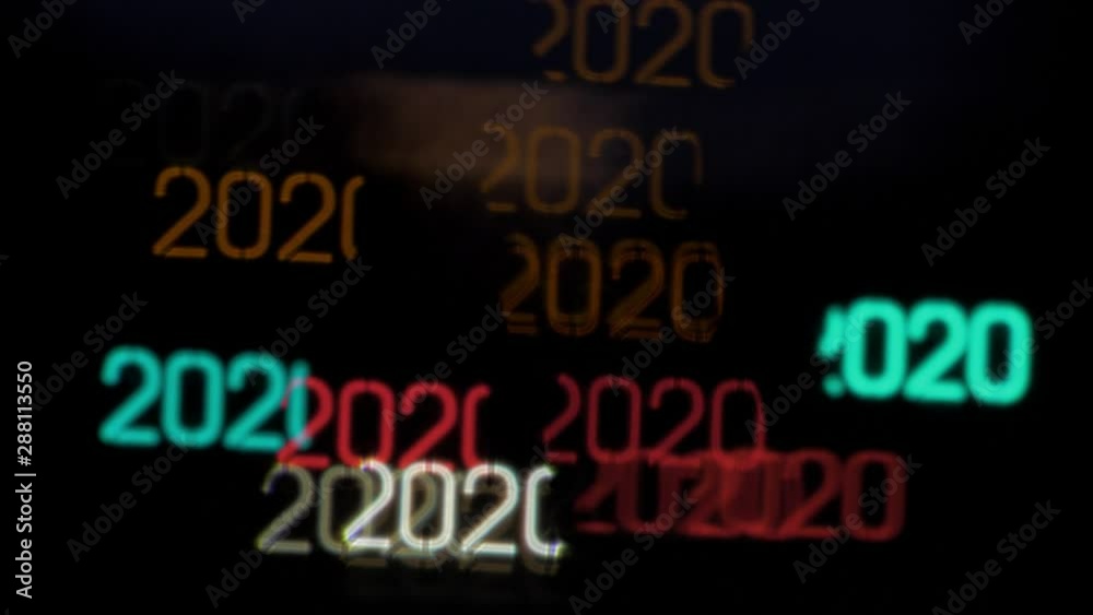 Colorful year 2020 shaped bokeh from moving car and traffic lights at the evening, Happy New Year or holiday concept background, copyspace Colorful year 2020 shaped bokeh from moving car and traffic lights at the evening, Happy New Year or holiday concept background, copyspace