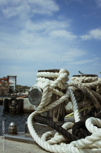 Mooring bollard, intertwined with mooring rope at the port in the Bay