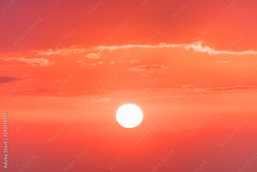 The sunset or sunrise. The cloudy sky cloured in red, orange, rose, scarlet, crimson, purple, violet and blue bright and vivid coloures with setting or rising sun in the evening or in the morning