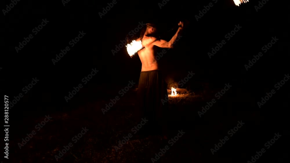 Fire show. Man juggles with two burning torches. Night show. Mastery of the fakir Fire show. Man juggles with two burning torches. Night show. Mastery of the fakir