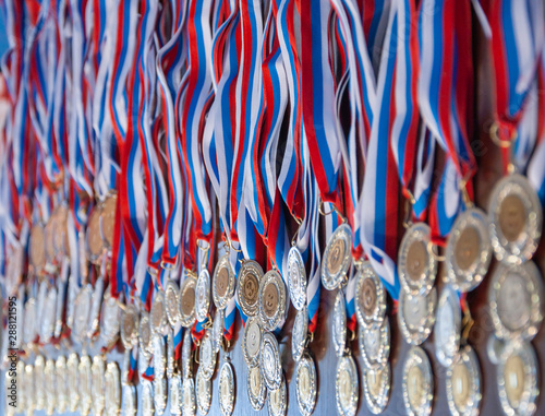 A lot of gold medals with ribbons
