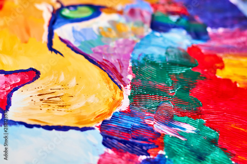A colorful lion on canvas drawn by a child using a brush and knife. Closeup, selective focus