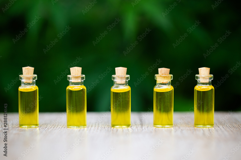 CBD hemp oil products, Cannabis oil against Marijuana plant. Herbal Treatment, Alternative Medicine CBD hemp oil products, Cannabis oil against Marijuana plant. Herbal Treatment, Alternative Medicine