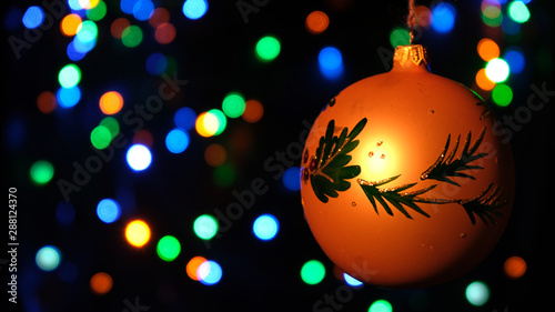 Christmas holiday card with ball, festive decor on a colorful background, bokeh. Space for the object.