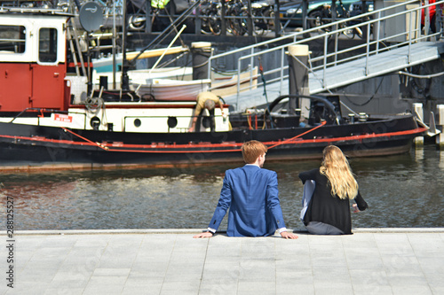 a man and a woman sitting on the pier Holland, Amsterdam