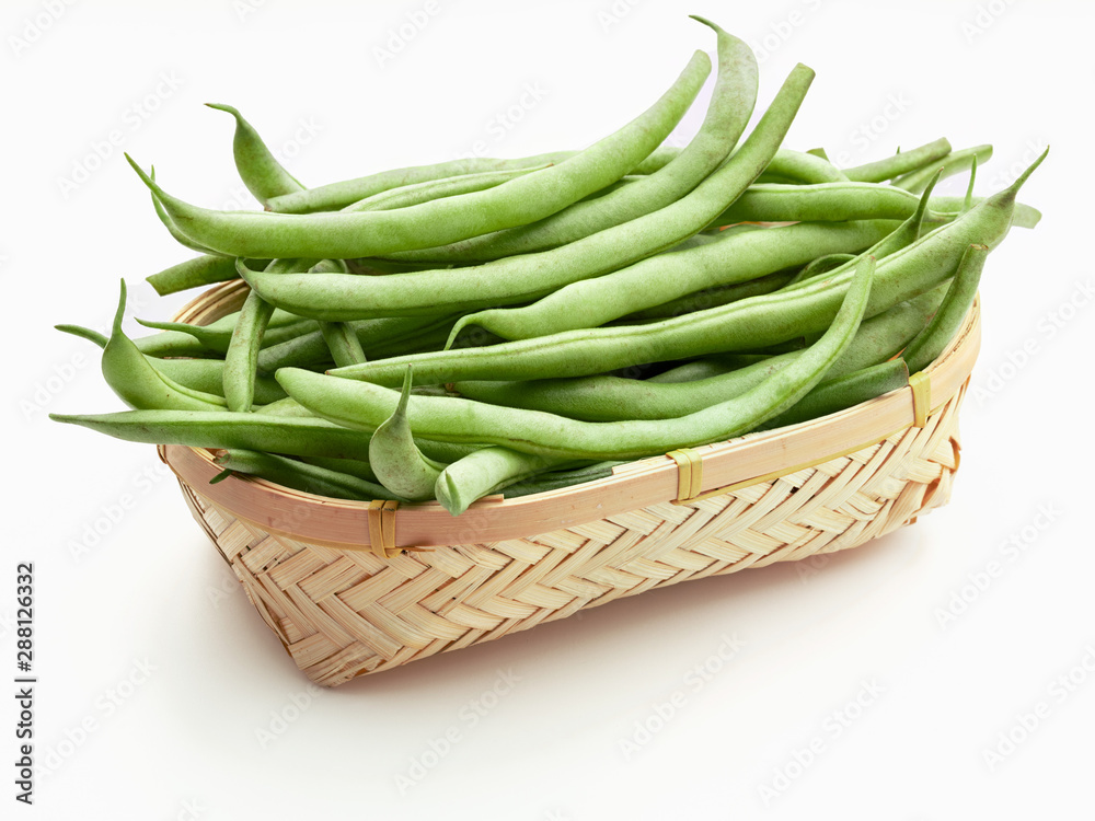 Fresh and raw green beans (green round beans) in wicker basket. Isolated on white background Fresh and raw green beans (green round beans) in wicker basket. Isolated on white background