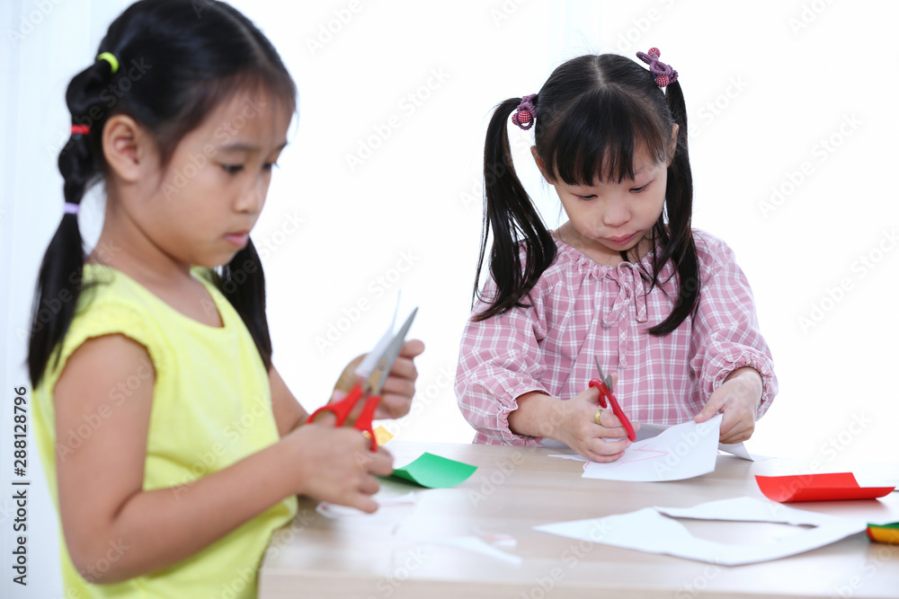 Home school education two girl cutting colored paper to do homework cut by scissors. Home school education two girl cutting colored paper to do homework cut by scissors.